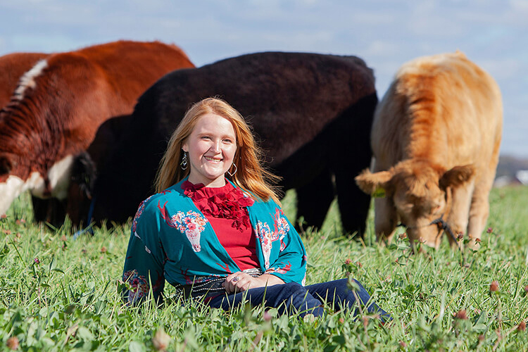 4h member Madelyn Zimmerman in field with cattle