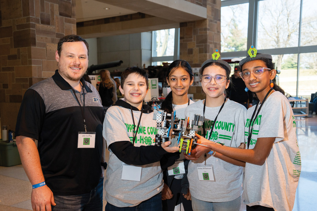 4-H Stem students hold their projects and smile.