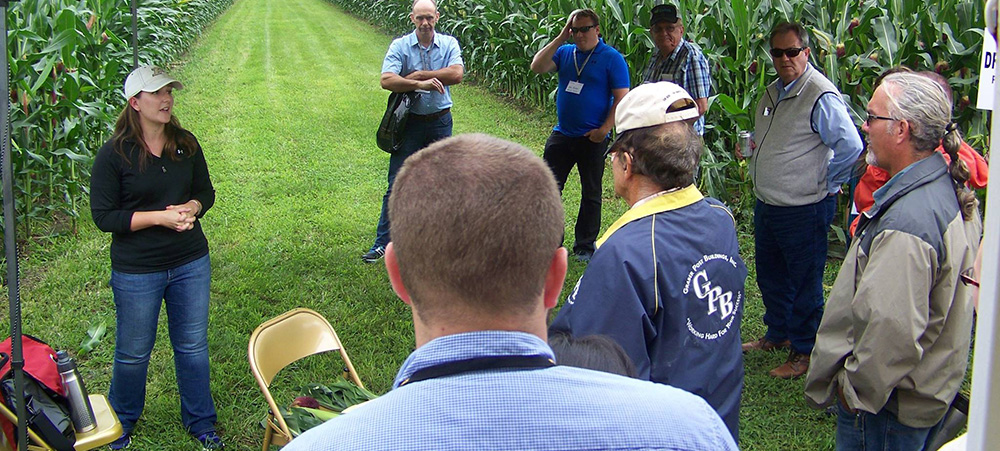 Image of a group of people in a field talking in a circle.