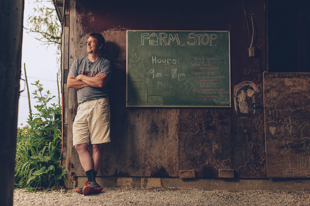 Photo of man standing next to chalk board.