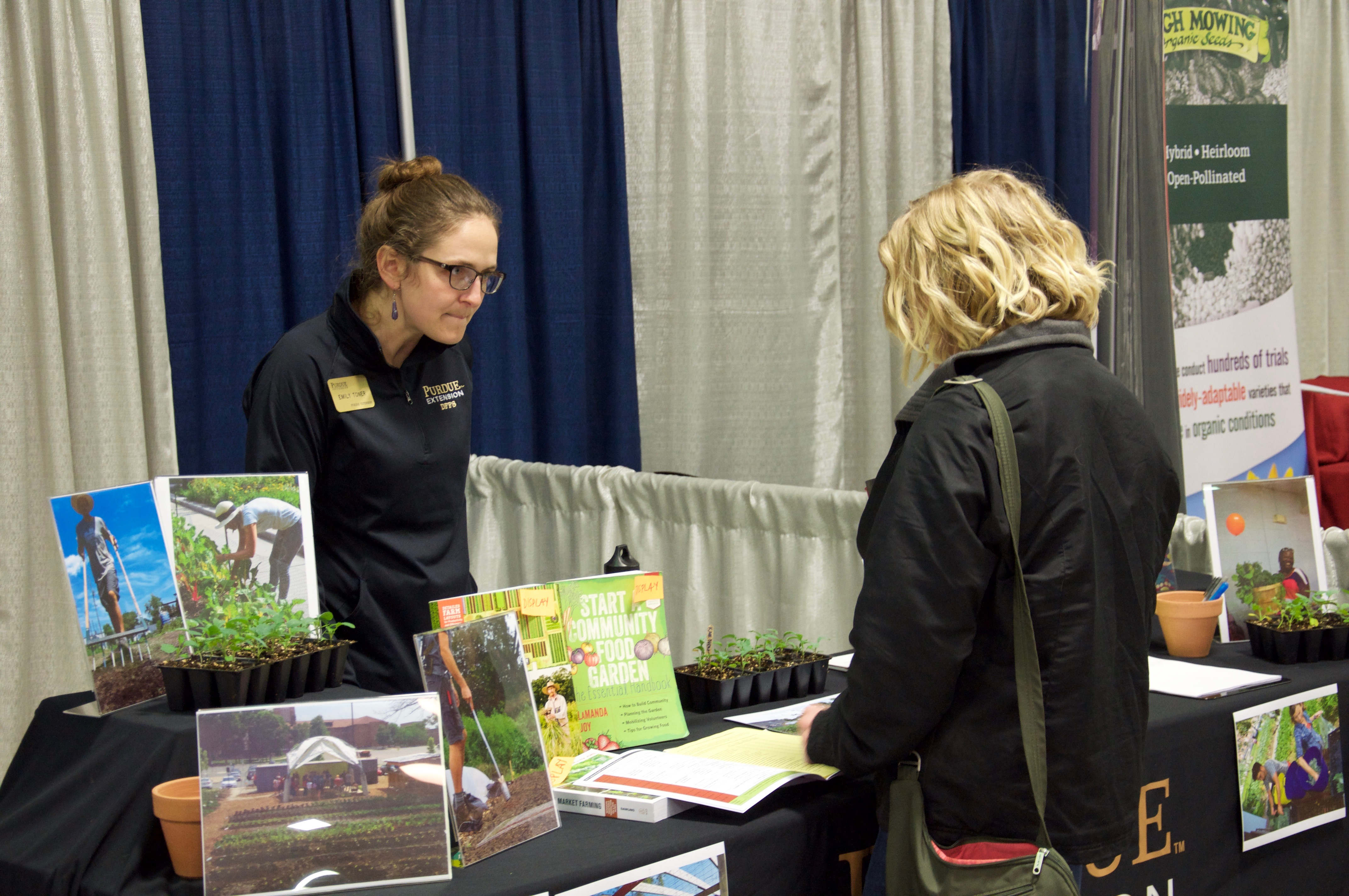 image of child harvesting carrots with the Indiana Small Farm Conference Logo