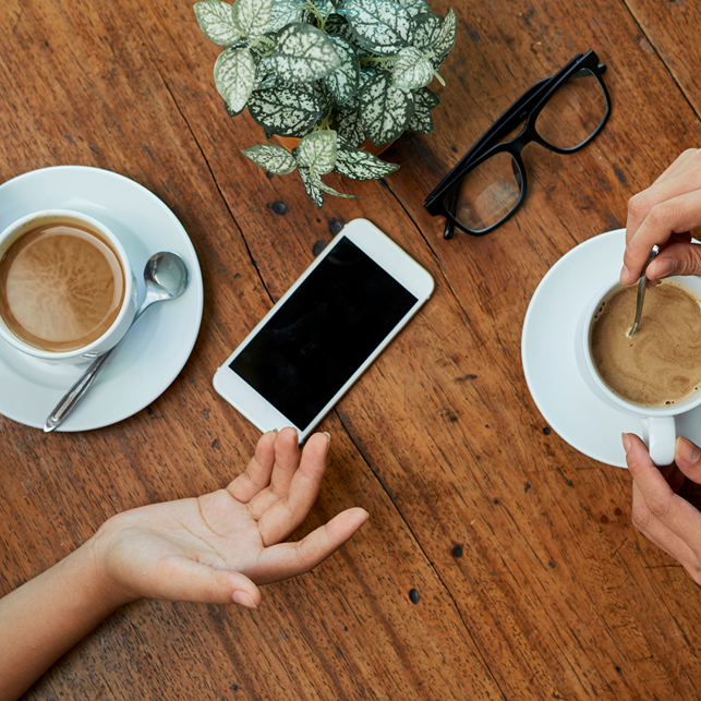 two hands with two coffee cups