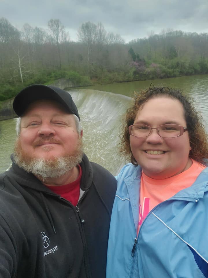 Nicole and Darrel Findley Standing in front of a waterfall. 