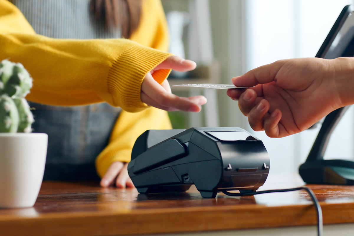 female hand handing over the credit card at the machine