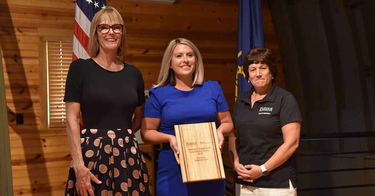 Women on stage with wooden award