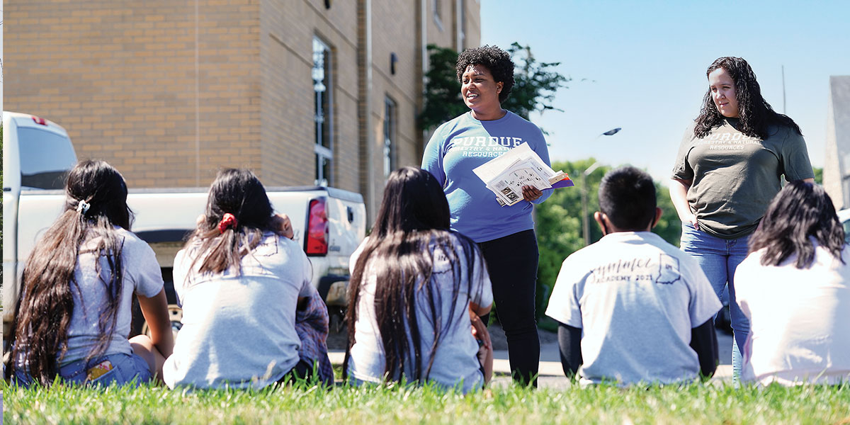 Purdue Extension Juntos adult leaders speak with youth participants.