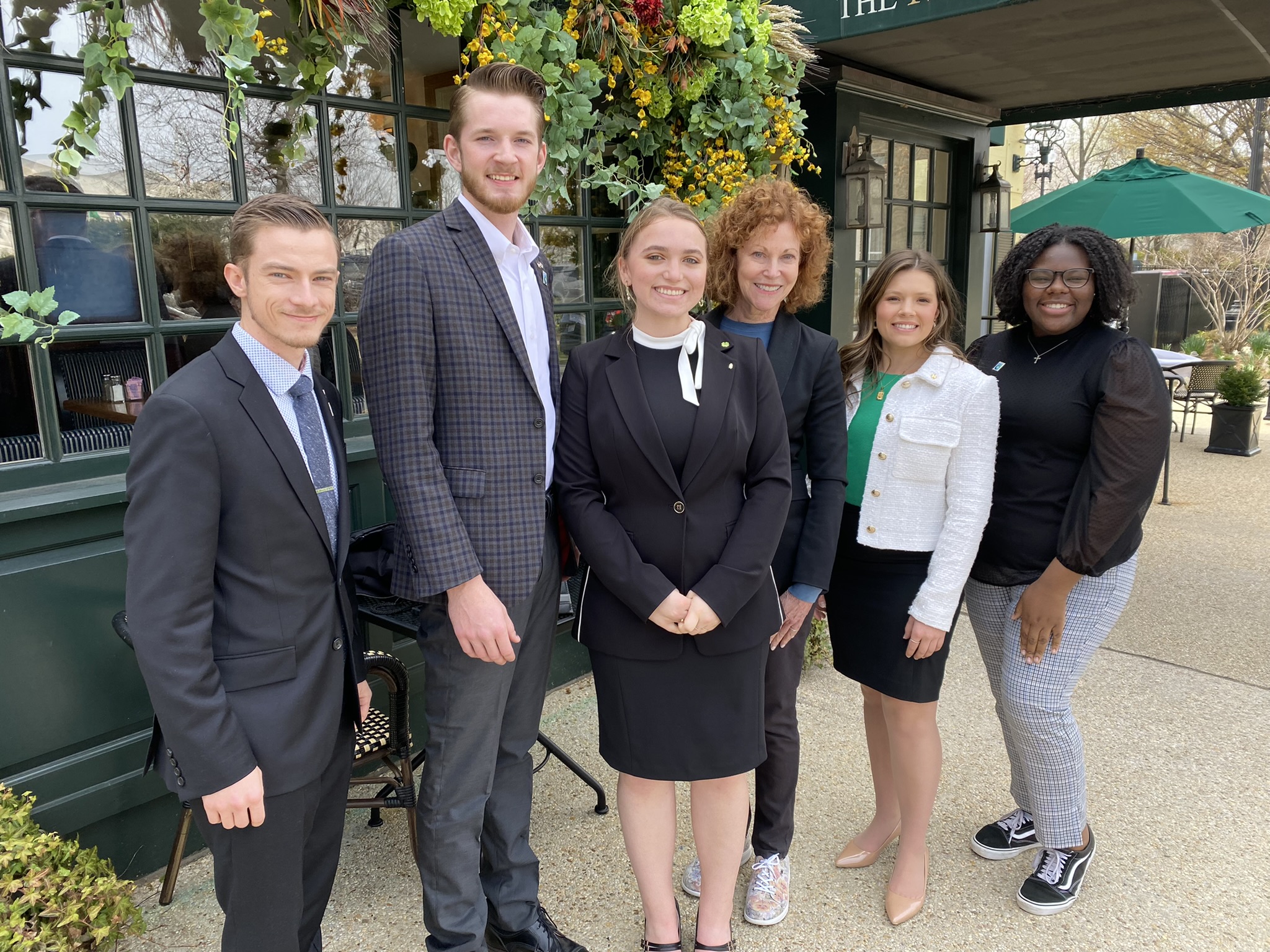 Six people pictured in front of restaurant.