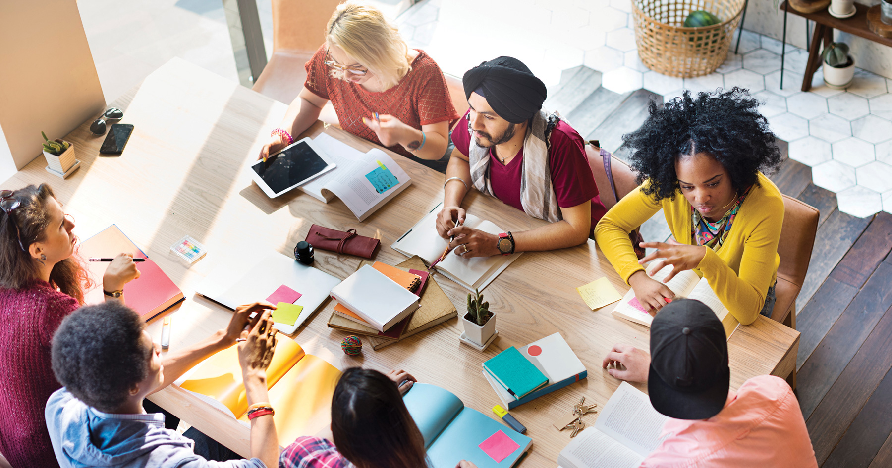 group of people sitting down at a table and discussing plans 
