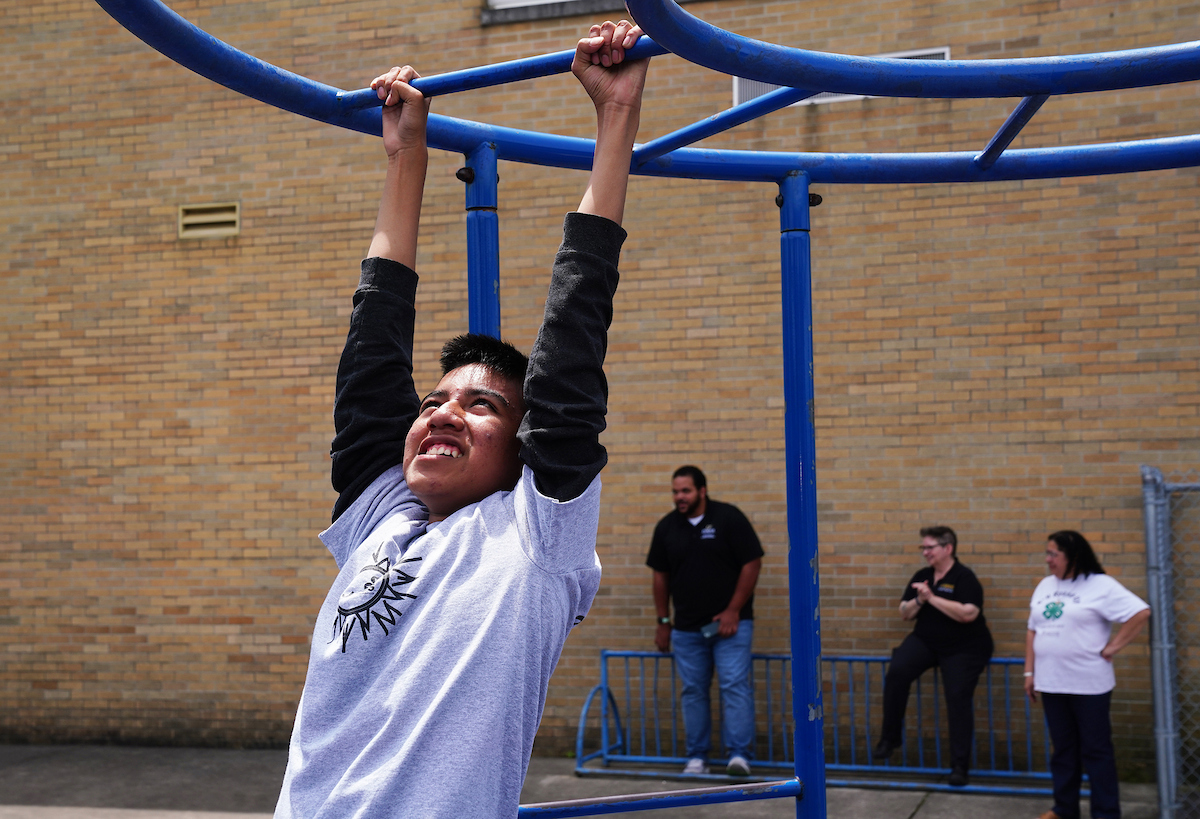 Juntos 4-H in Indiana, teen boy playing on monkey bars