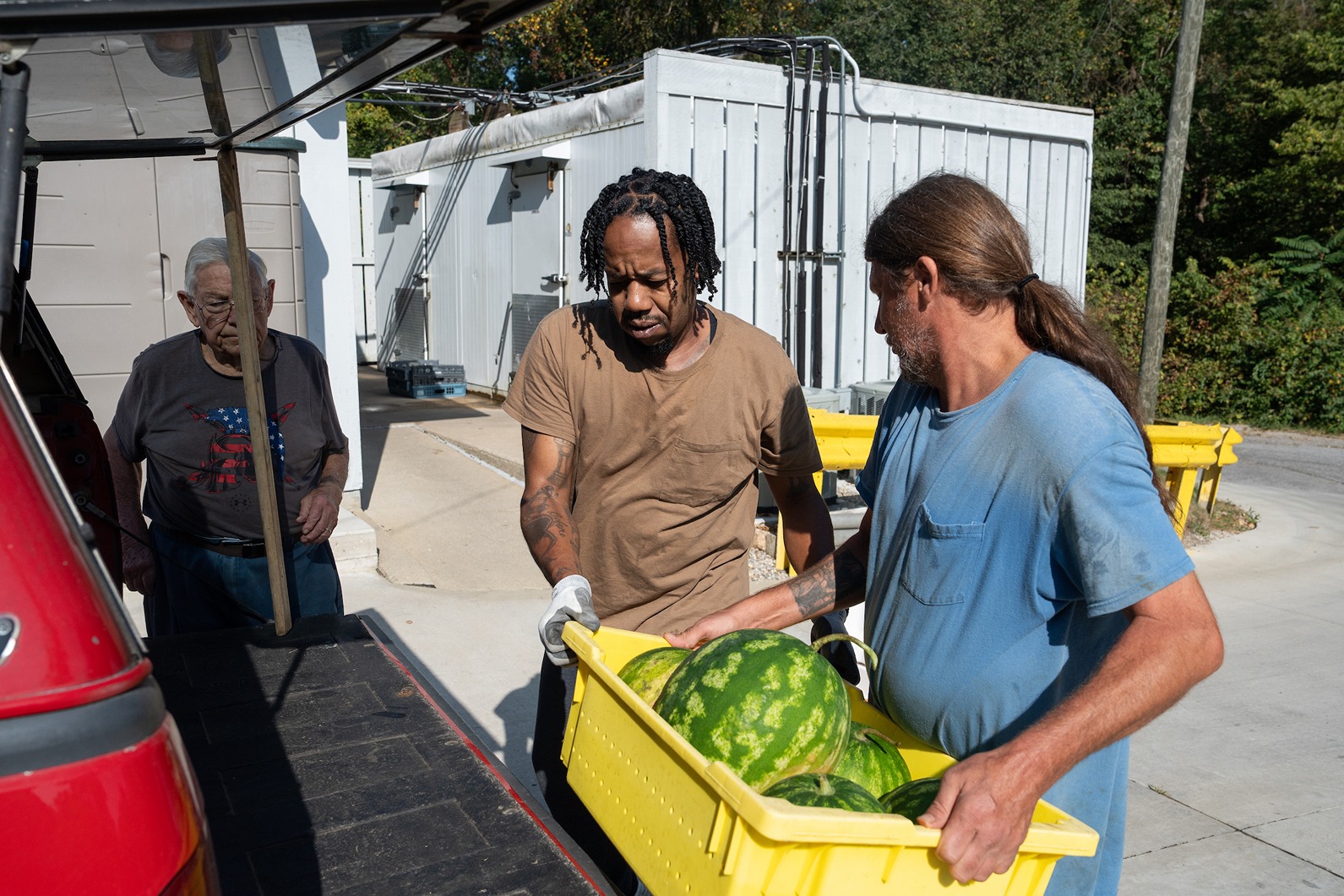 Two MG trainees putting food in the truck for the food bank.