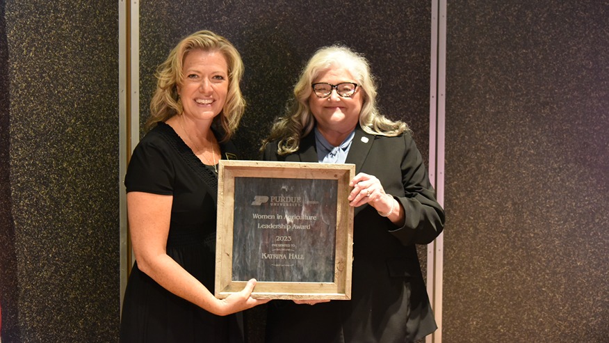Angie Abbott and Katrina Hall pose with Hall’s award plaque