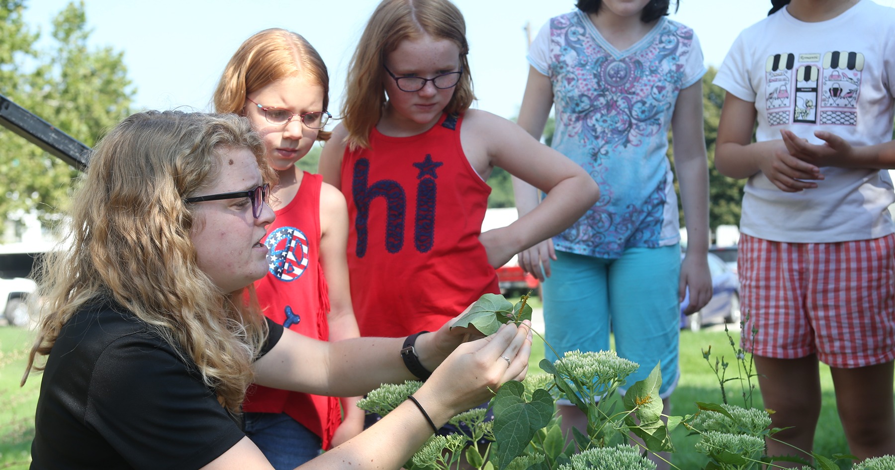 Extension educator Ashley Adair shows youth pests on a leaf; Photo credit: Banner by Tom Campbell