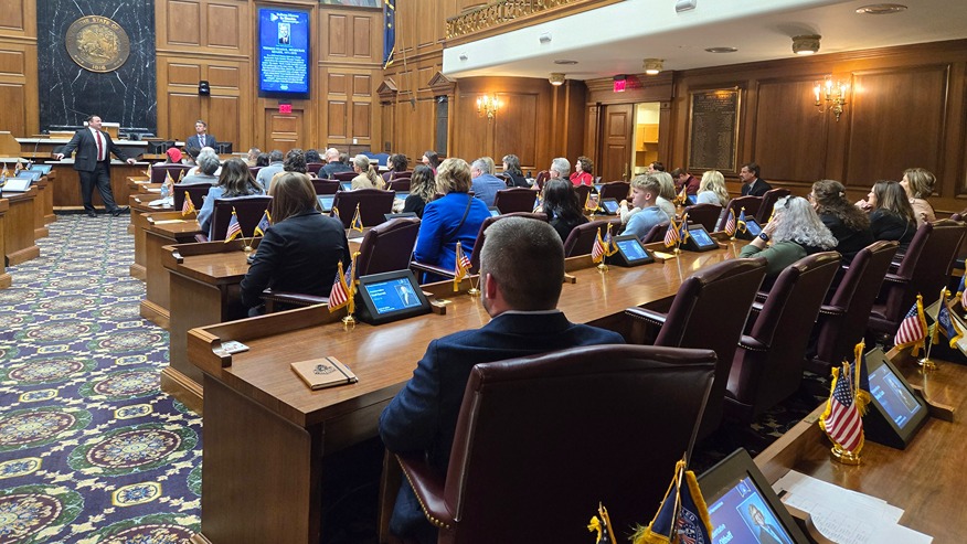 A group of people sit in the Indiana House chambers 