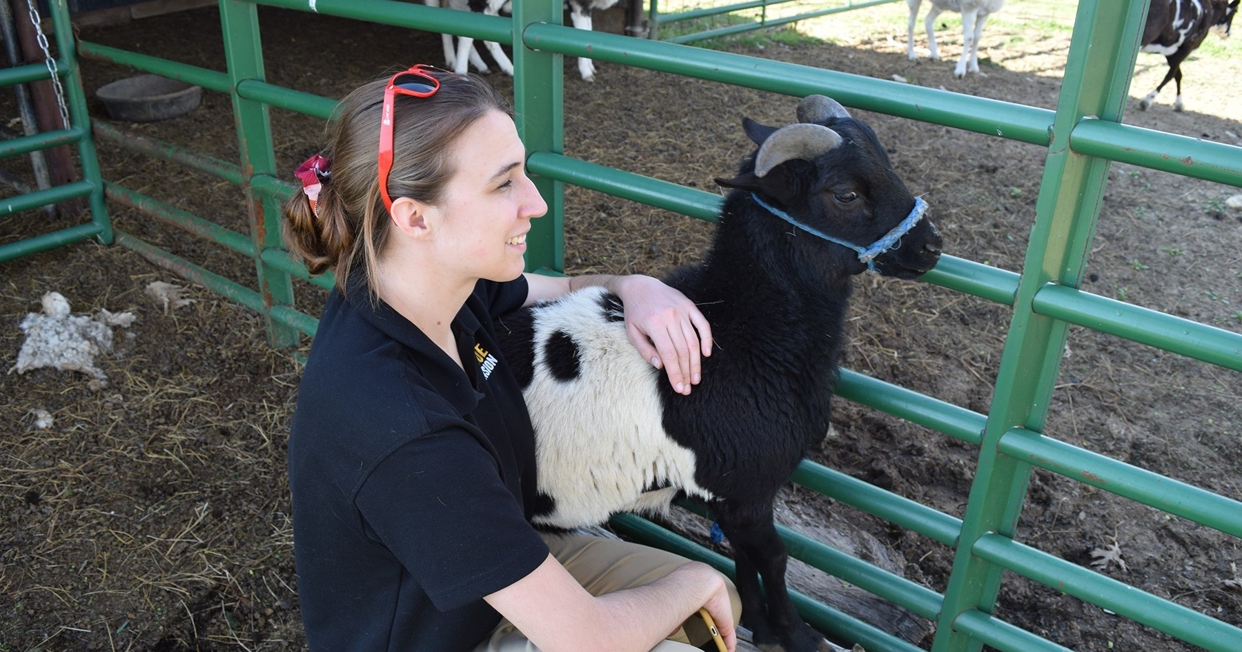 Cora Reinbolt smiling with a goat