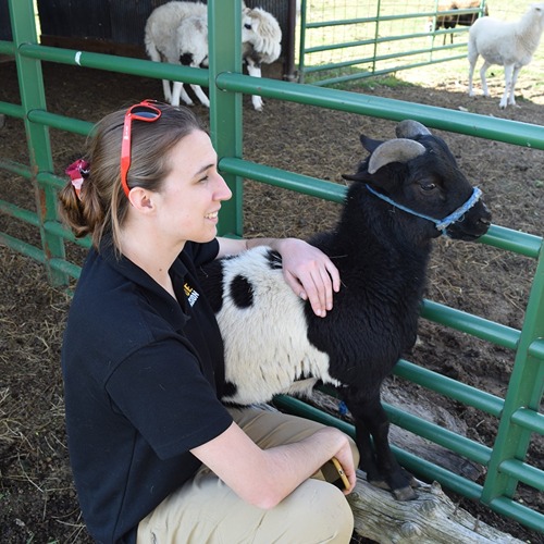 Cora Reinbolt smiling with a goat