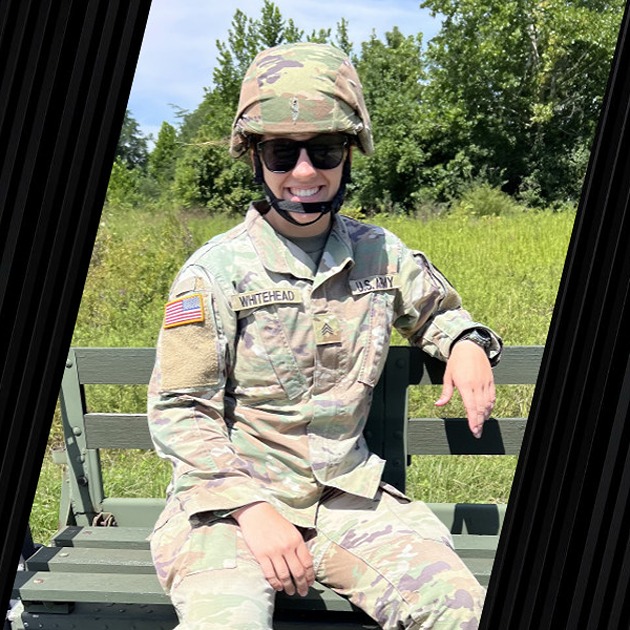 A veteran in her military uniform is smiling.