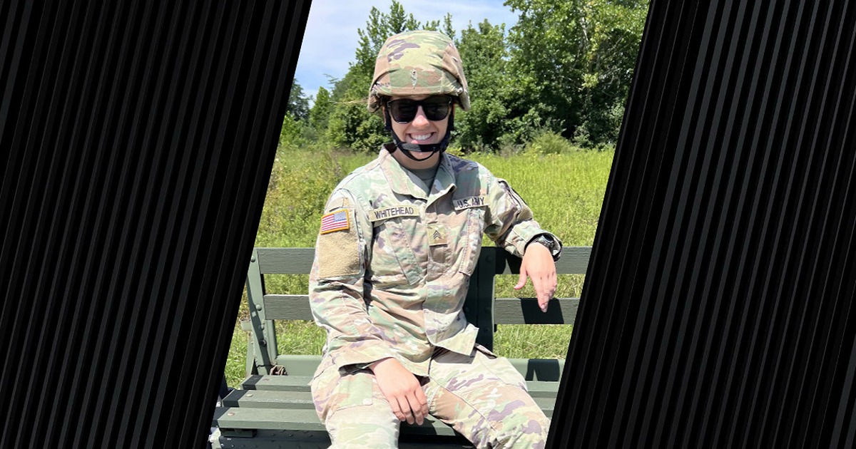 A veteran in her military uniform is smiling.