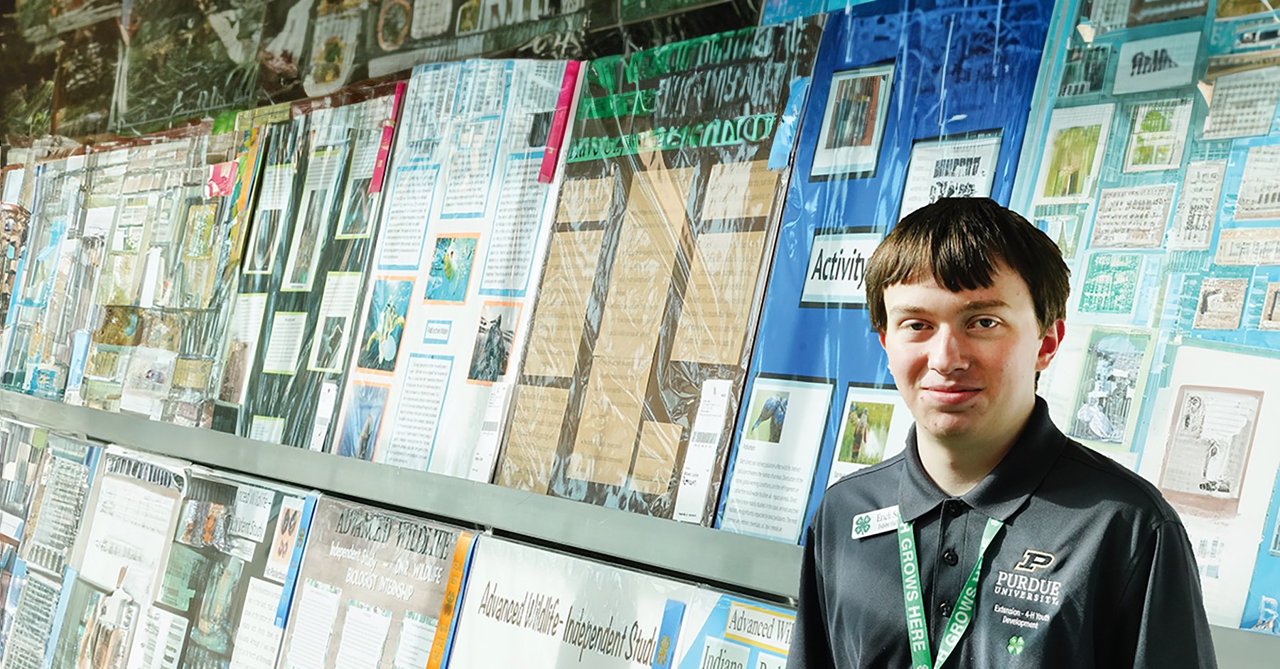 young male in front of a big poster wall