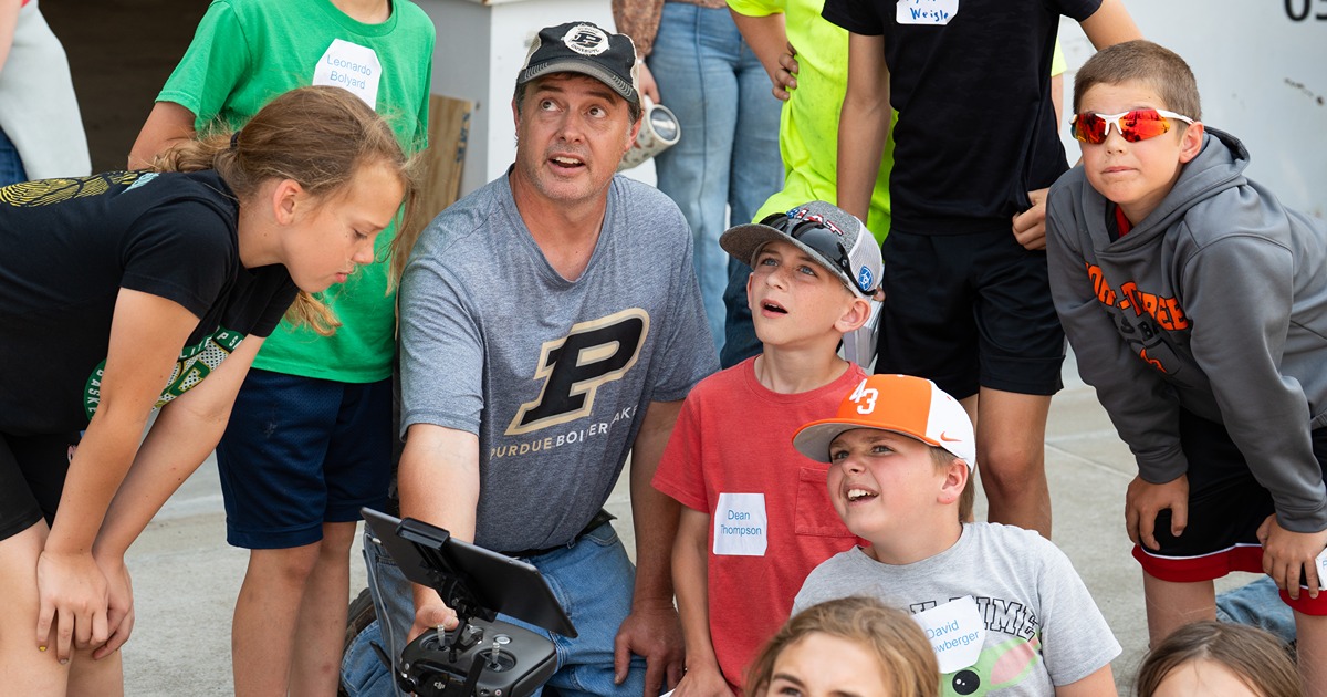Youth learn about science and technology from a Purdue Extension educator, teaching them about drones.