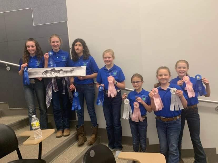 children holding up winning ribbons
