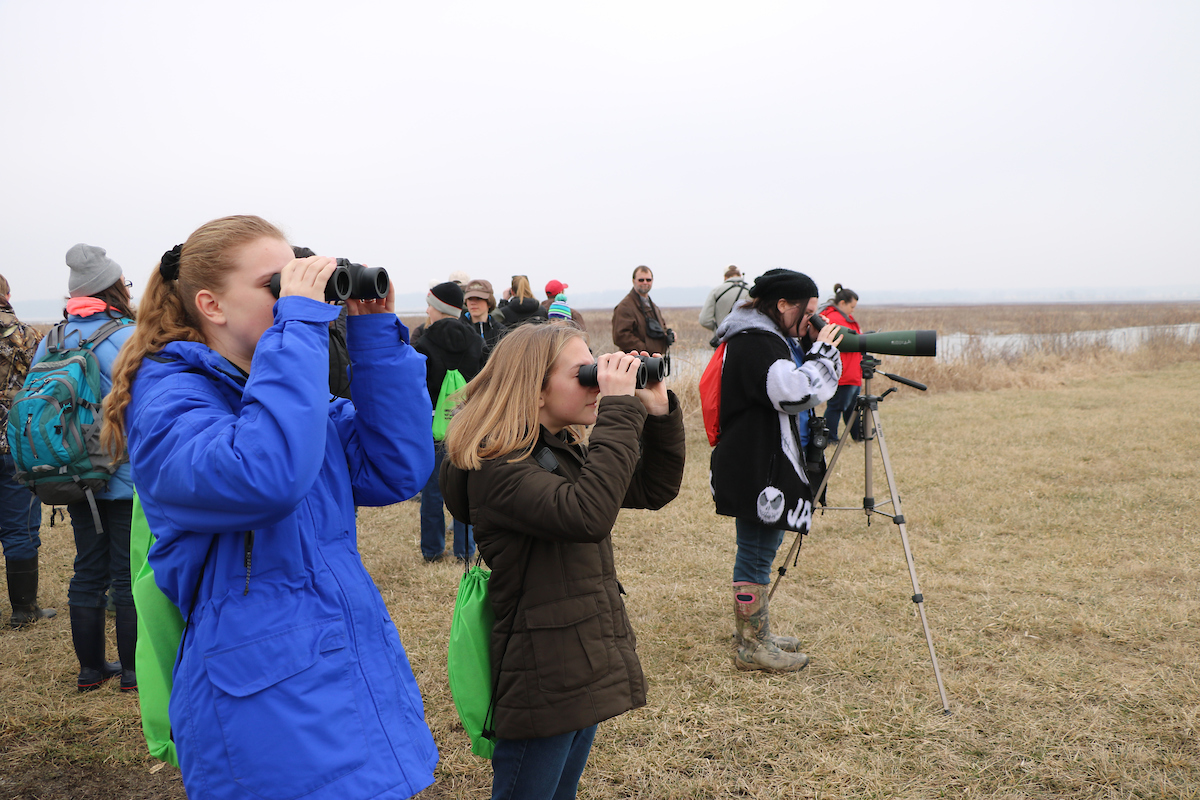 People searching through binoculars